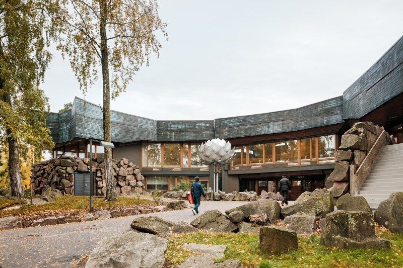 Dipoli venue from the outside with a pine statue. 